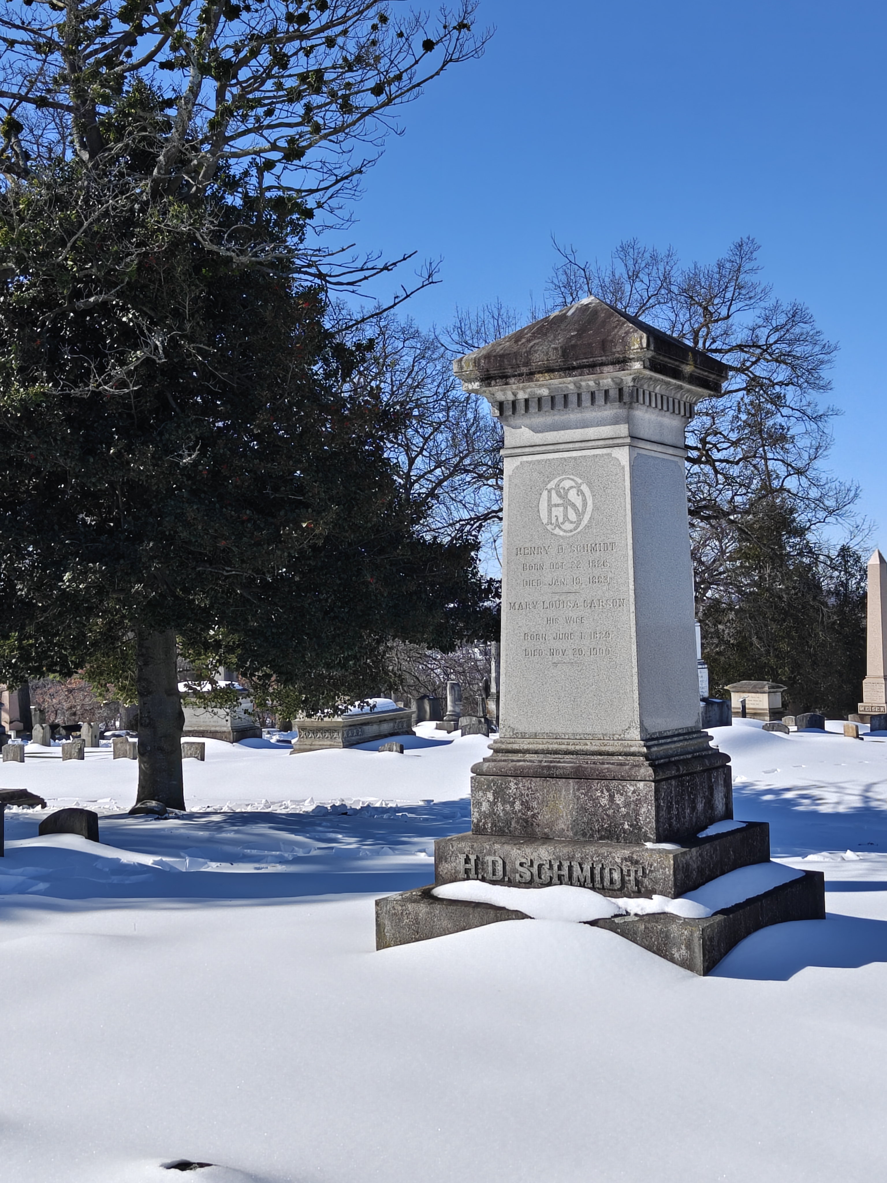 Three-quarters front right view of Henry B. Schmidt's large gravestone monument, with snow in the foreground.